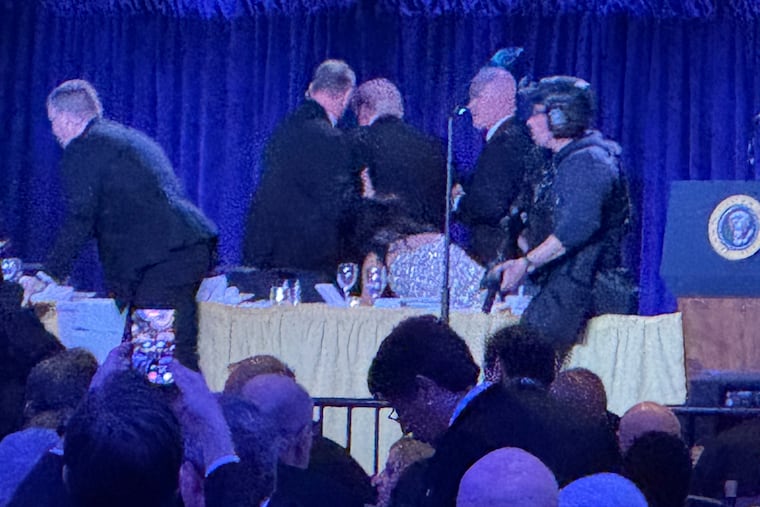 Secret Service agents surround President Donald Trump, third from left, as he is taken from the stage after a shooting incident outside the ballroom during the White House Correspondents Dinner in Washington on Saturday.