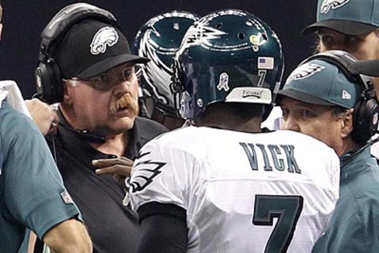 Eagles head coach Andy Reid talks to quarterback Michael Vick during the team's game against the Saints. (Ron Cortes/Staff Photographer)