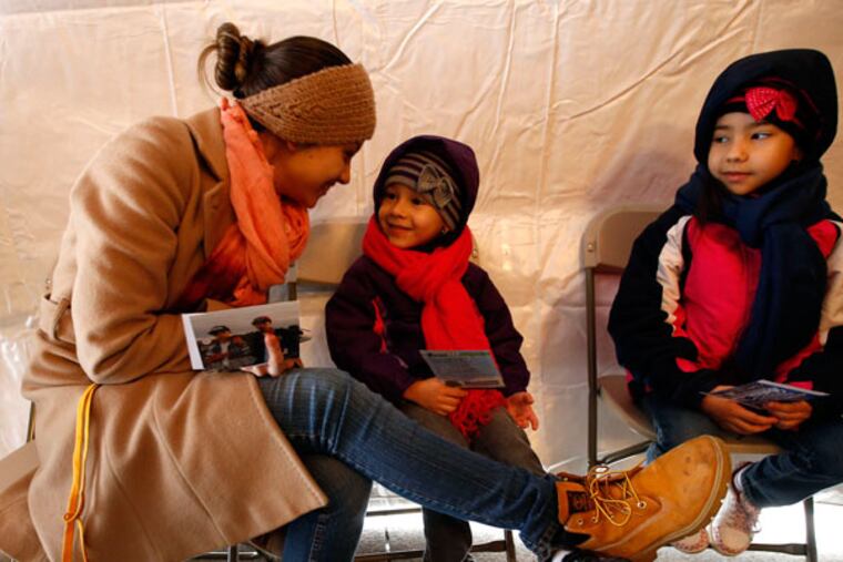Normita Santiago spends some time with her daughters Bellamia (center) and Destiny during an "I Love Philly" party Saturday, Feb. 14, 2015, at LOVE Park. ( YONG KIM / Staff Photographer )