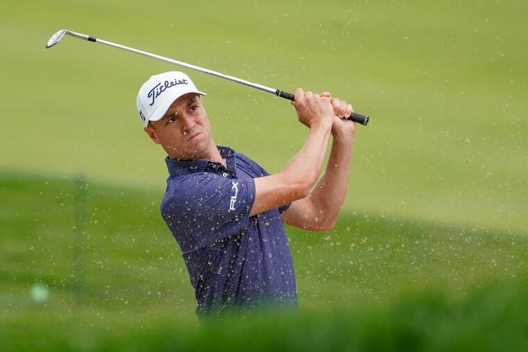 Justin Thomas plays a shot from a bunker on the 17th hole.