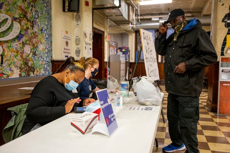 Christine Ross (left) helps James Galloway Jr. with his voter registration at Broad Street Ministry.