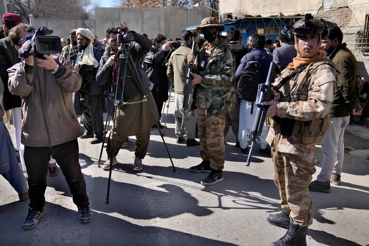 Afghan cameramen cover a protest against U.S. President Joe Biden in Kabul, Afghanistan, Tuesday, Feb. 15, 2022.