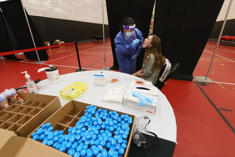 Registered Nurse Chantey White, left, administers a COVID-19 test to freshman Victoria Flint at Ursinus College last September. Students were required to be tested once a week.
