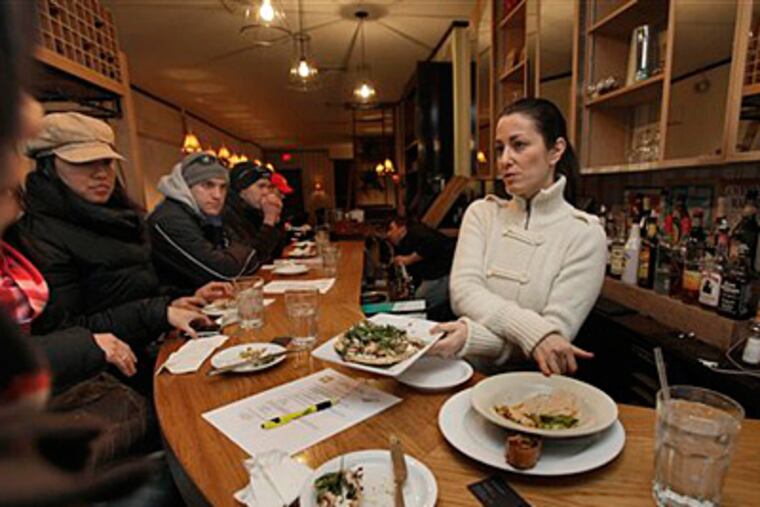 This photo taken Jan. 29, 2010 shows Nikki Cascone, right, a contestant on the fourth season of cable television's "Top Chef," as she meets with people attending "In the Steps of a Top Chef " with City Food Tours, in her New York restaurant 24 Prince. (AP Photo/Richard Drew)