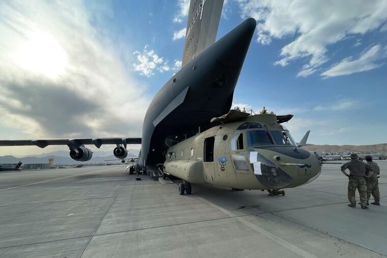 A CH-47 Chinook from the 82nd Combat Aviation Brigade, 82nd Airborne Division is loaded onto a U.S. Air Force C-17 Globemaster III at Hamid Karzai International Airport in Kabul, Afghanistan.