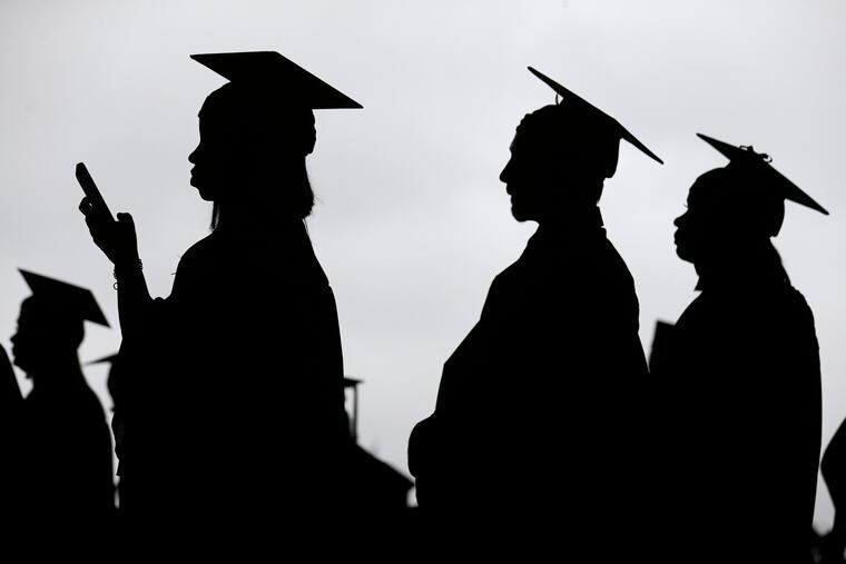 FILE - In this May 17, 2018, file photo, new graduates line up before the start of the Bergen Community College commencement at MetLife Stadium in East Rutherford, N.J. A college degree has long been a ticket to the U.S. middle class. Yet a new survey shows that college graduates aren’t as likely as they once were to feel they belong to the middle class. (AP Photo/Seth Wenig, File)