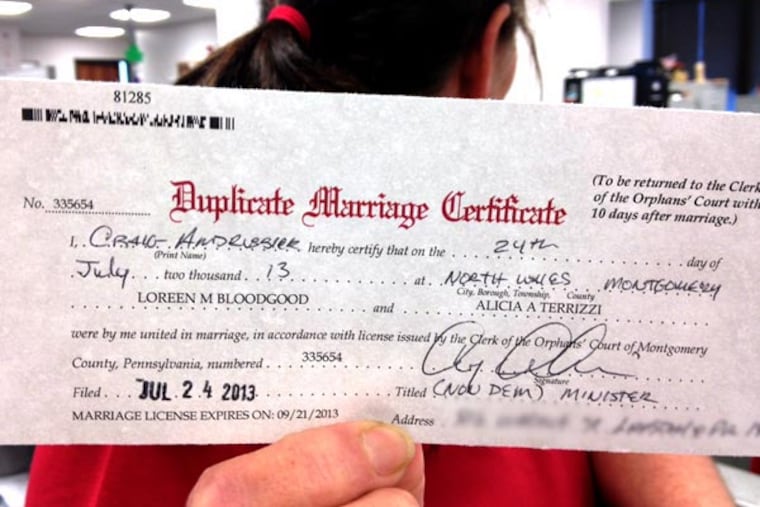July 24, 2013 file photo: A staffer in the Montgomery County Register of Wills department, who did not want to be identified, holds up the first marriage license for a gay couple. (JESSICA PARKS / Staff)