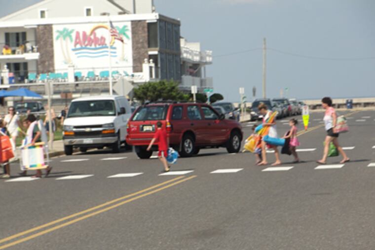 Pedestrians leaving the beach in North Wildwood cross the street at the busy intersection at 3rd and JFK Boulevard.