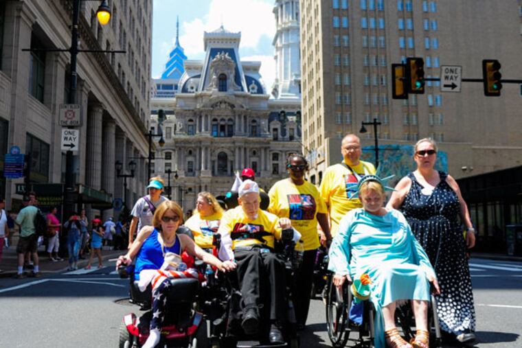 Participants lead the parade on Broad Street during the 25th anniversary of the Americans with Disabilities Act in Philadelphia on Saturday, July 25, 2015. (MICHAEL PRONZATO / Staff Photographer)