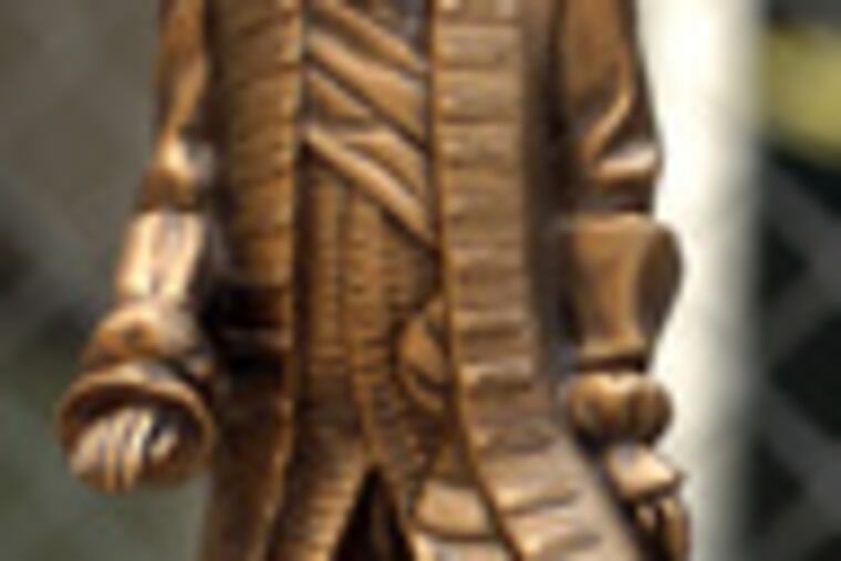 Small statue of William Penn tops Comcast Tower. Guests of recent ceremony signed steel beam below statue.