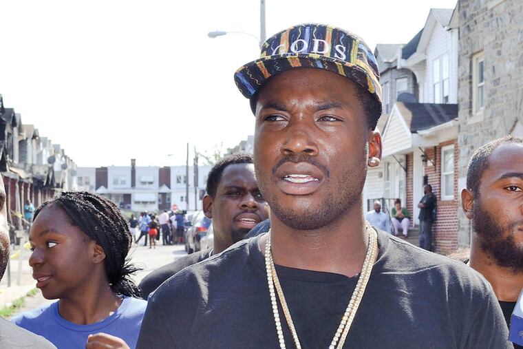 Philadelphia hip hop artist Meek Mill looks around the Gesner Street fire site Tuesday. Now, he's in jail.