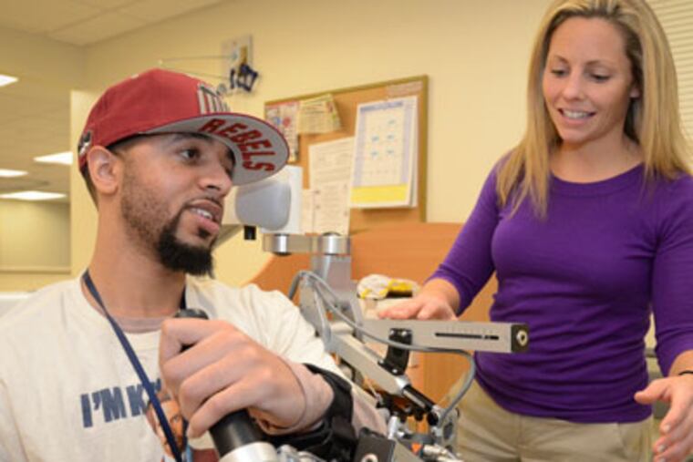 Brent Wylie works with occupatioal therapist Melissa Muller during a rehab session for damage sustained to his left arm after a stroke. November 29, 2012 ( RON TARVER / Staff Photographer )