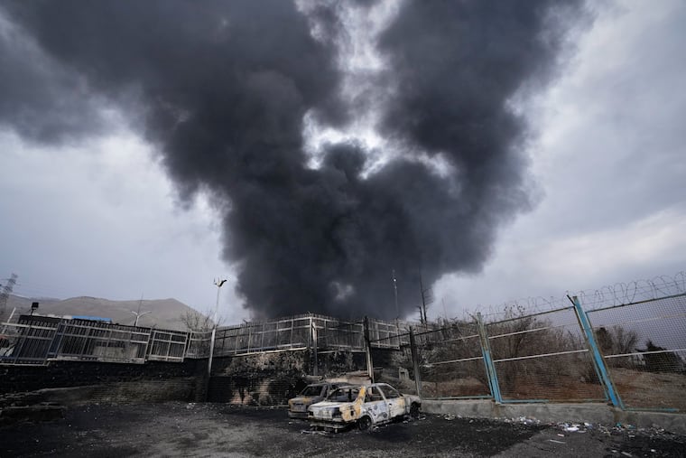 FILE - A thick plume of smoke rises from an oil storage facility hit by a U.S.-Israeli strike in Tehran, Iran, March 8, 2026.