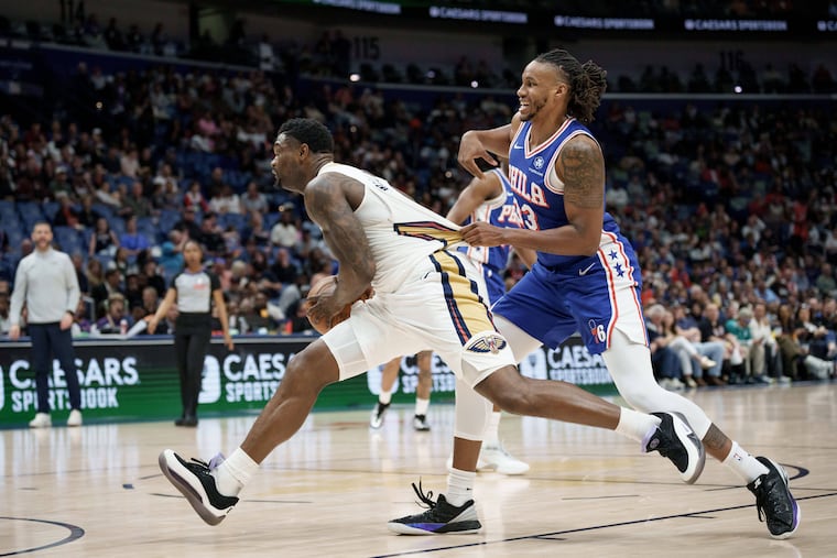 Pelicans forward Zion Williamson (left) is grabbed by Sixers forward Jabari Walker in Saturday night's game in New Orleans.