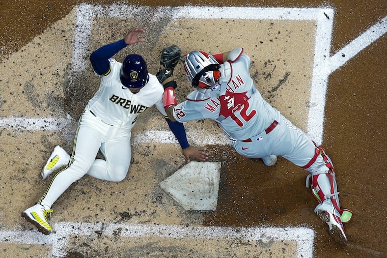 The Brewers' Eduardo Escobar scores safely past Phillies catcher Rafael Marchan during the third inning Tuesday in Milwaukee. Escobar scored from second on a hit by Christian Yelich.