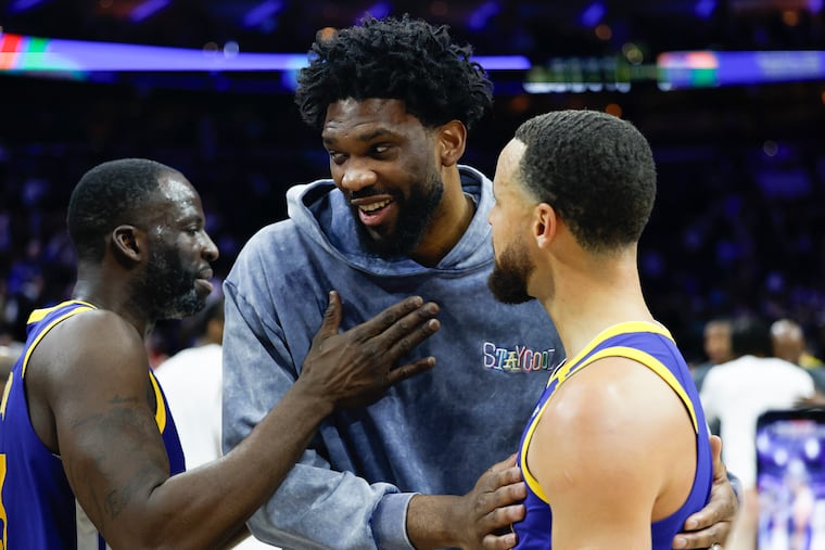 Injured Sixers center Joel Embiid with Golden State Warriors guard Stephen Curry (right) and forward Draymond Green after the Sixers beat the Golden State Warriors, 126-119, on Saturday.