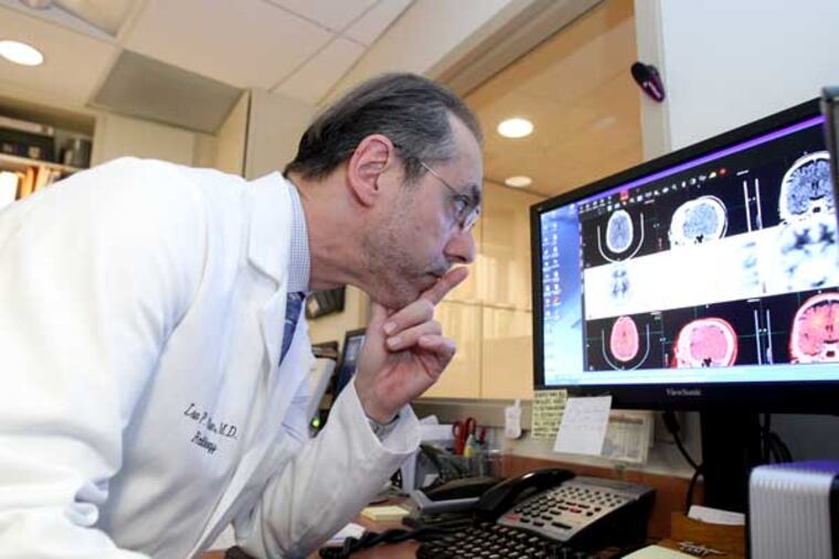Dr. Lee Adler of the Adler Institute for Advanced Imaging looks over the scans of a patient's brain. ( Charles Fox / Staff Photographer )