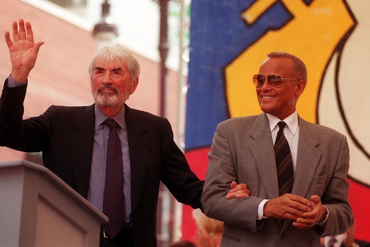 Gregory Peck waves to the crowd after recieving the Marian Anderson Award as he is escorted off stage by Harry Belafonte in 1999. Belafonte was the 1998 recipient. The award is given to an artist who use their talents for personal artistic expression coupled with a deep commitment to the betterment of society.