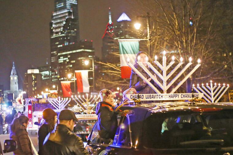 Menorahs sit on top of cars lined up along Ben Franklin Parkway before the beginning of a Hanukkah parade which ended at Independence National Park on Saturday, December 20, 2014.