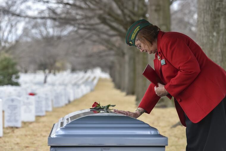 Eileen Skahill, national chaplain of the Women Marines Association, places her hand on the casket of retired Marine Master Sgt. Catherine G. Murray.