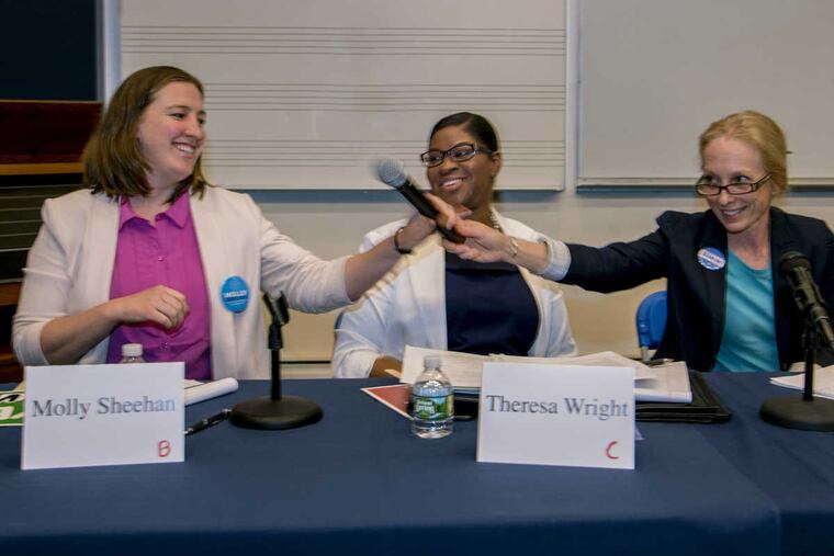 Democratic Fifth Congressional District primary candidates (from left) Molly Sheehan, Theresa Wright, and Mary Gay Scanlon pass the shared microphone across the table to next speaker during their debate at Cabrini University May 1, 2018.