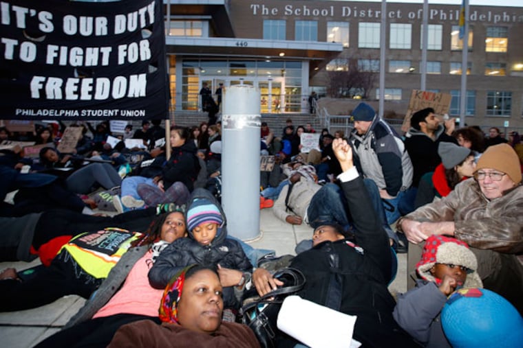 Students and supporters participate in a "die-in" at school district headquarters along North Broad Street on Thursday, Dec. 18, 2014. ( YONG KIM / Staff Photographer )
