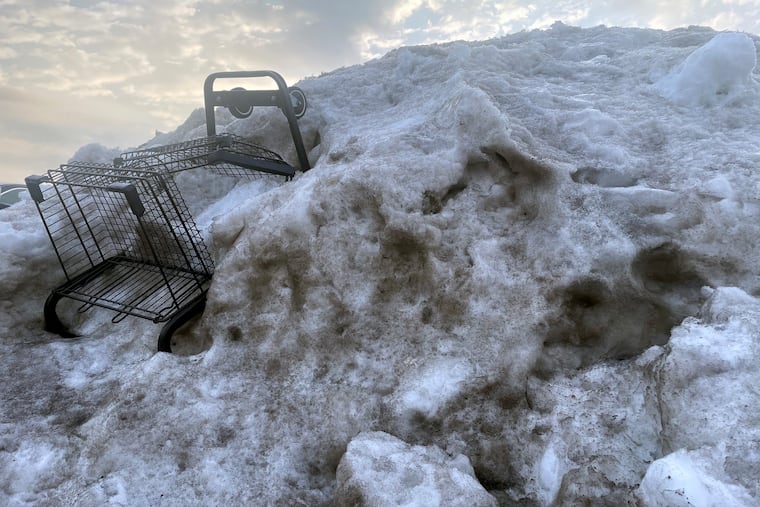 In Cherry Hill, assorted detritus emerges from ice and snow pile on Saturday. The melt is picking up speed.