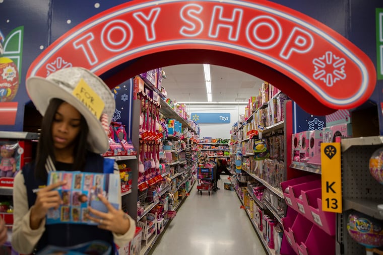 Aiona Walker, left, helps a customer while Sharon Woods shops for toys at the Walmart located at 1675 S. Christopher Columbus in Philadelphia on Friday, Nov. 16, 2018. This will be the first Black Friday without Toys R Us, resulting in Walmart and other competitors vying to fill that void. HEATHER KHALIFA / Staff Photographer