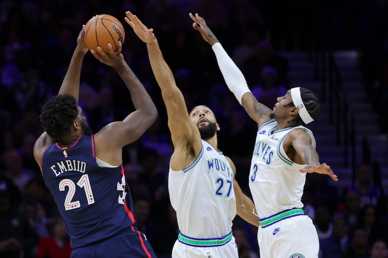 Sixers center Joel Embiid is defended by Minnesota Timberwolves' Rudy Gobert, center, and forward Jaden McDaniels in the third quarter on Wednesday. Sixers won, 127-113.