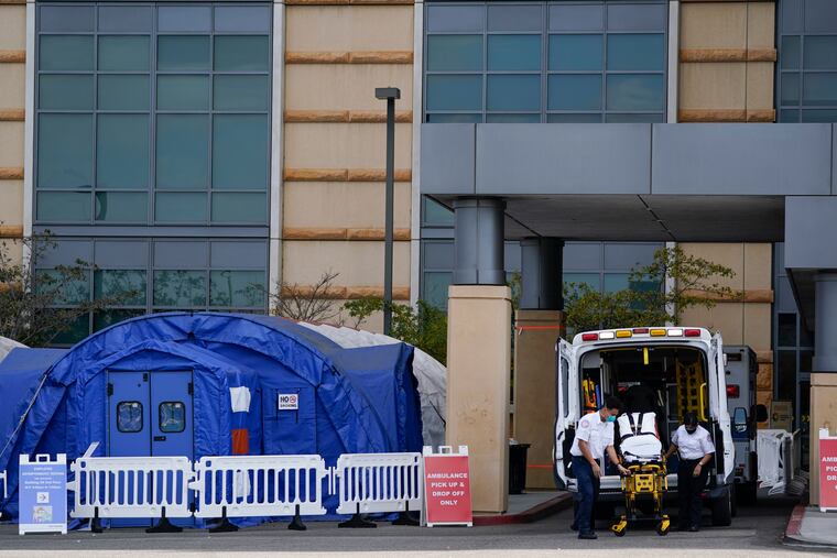 Medical workers remove a stretcher from an ambulance near medical tents outside the emergency room at UCI Medical Center, in Irvine, Calif. Dec. 17, 2020. The recent federal stimulus package included efforts to tamp down surprise medical bills given to patients who unknowingly receive out-of-network care.