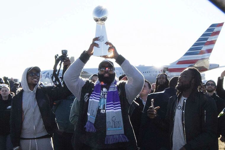 Eagles players take turns holding up the Vince Lombardi Trophy while displaying it to fans gathered to welcome them in Philadelphia a day after defeating the New England Patriots in Super Bowl 52 in Minneapolis, Monday, Feb. 5, 2018.