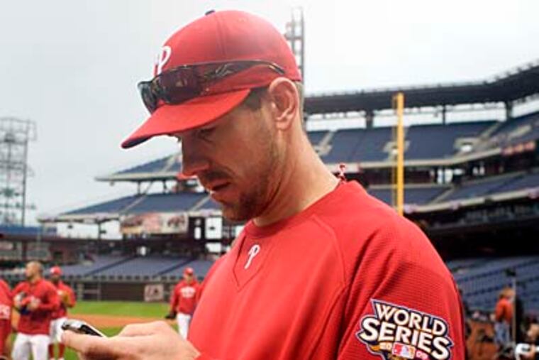 Cliff Lee checks his e-mail during Friday's team practice at Citizens Bank Park. (Ed Hille / Staff Photographer)