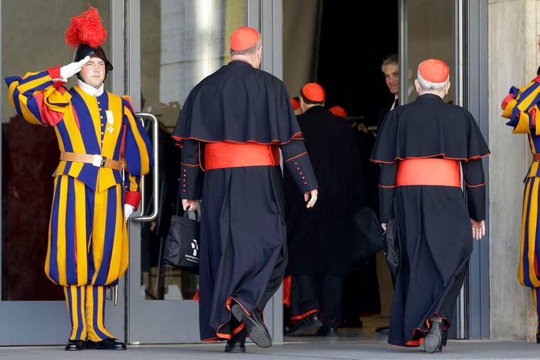 Swiss guards salute as cardinals arrive at the Vatican for Monday's meeting. There were 107 cardinals in attendance; 115 are eligible to vote for a pope and the others are making their way to there.