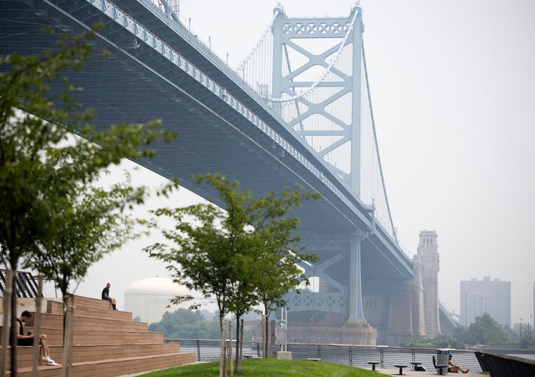 John Burns Jr., of Grays Ferry, sits at the Cherry Street Pier amid wildfire smoke from Canada on Thursday.