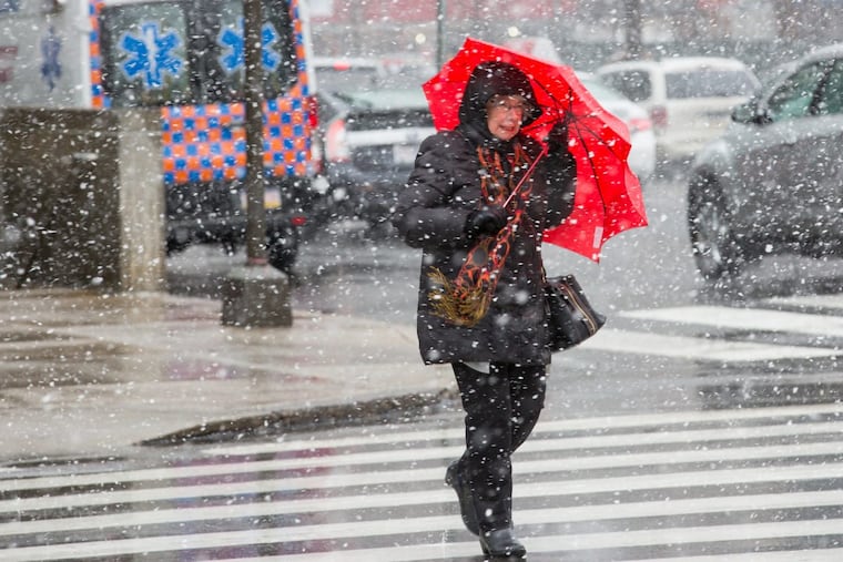 A pedestrian uses an umbrella to brace against the inclement weather at 15th and JFK Blvd., in Center City Philadelphia, Friday, March 2, 2018.