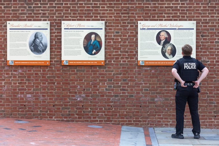 U.S. Park Police Officer Patrick O’Hanlon reads the new panels at the site of the President’s House at Independence Mall on July 16.