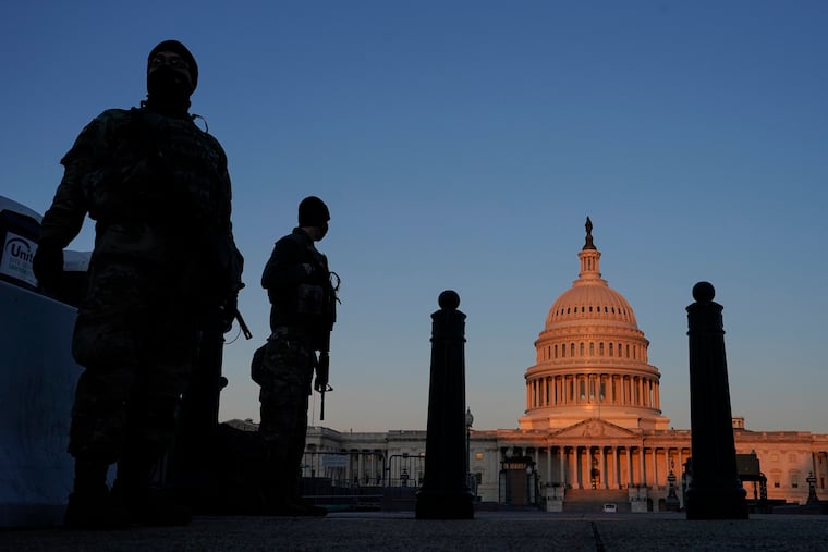 National Guard members standing their posts around the Capitol at sunrise in Washington on Monday.