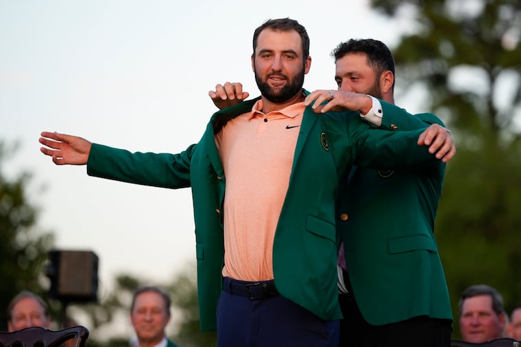 Jon Rahm, of Spain, puts the green jacket on winner Scottie Scheffler, his second Masters win over the last three years.