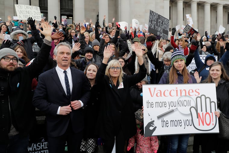 Robert F. Kennedy Jr. (left) stands with protesters at the Capitol in Olympia, Wash., in 2019, where they opposed a bill to tighten measles, mumps, and rubella vaccine requirements for school-age children.