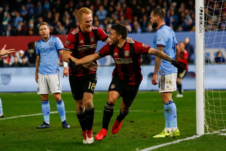 Atlanta United's Eric Remedi (center) celebrates with teammate Jeff Larentowicz after scoring a goal against New York City FC