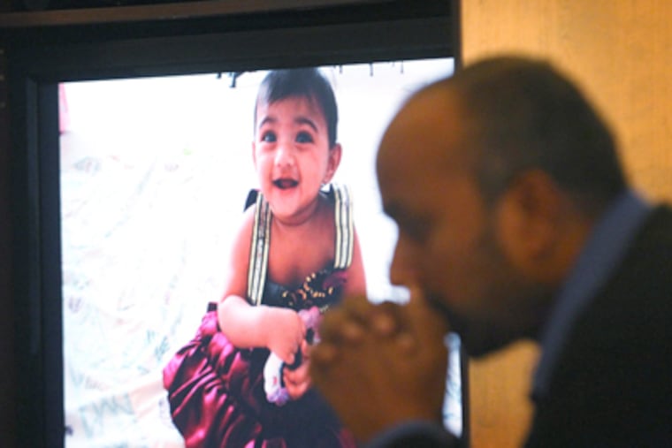A slide of Saanvi Venna, slain last week, as Subash Karra sits nearby. (Charles Fox / Staff Photographer)