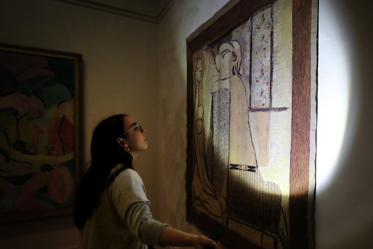 AnnaLivia McCarthy, senior conservation coordinator at the Barnes Foundation, demonstrates how she approaches pest management at the museum in Philadelphia. One of McCarthy’s roles is to inspect the museum for pests that could potentially damage the art. She is pictured with a Picaso tapestry.