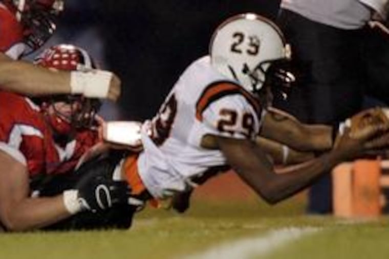 Pennsbury's Jordan Lollis drags Neshaminy players into the end zone on a 7-yard touchdown run Friday night. Neshaminy won the game by a score of 16-13; both squads are headed to the Class AAAA playoffs.