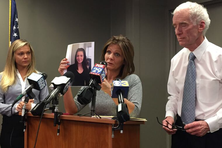 Joanne DeGuio holds up a picture of her daughter Amanda as Amanda's sister Nicole looks on at left. Upper Darby police Superintendent Michael Chitwood is at right.