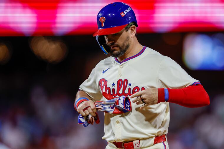 Kyle Schwarber takes off his gloves after making the last out.