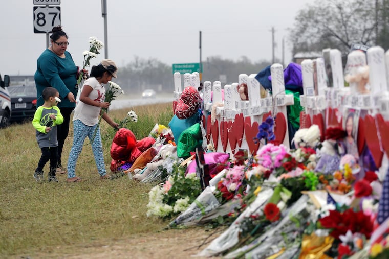 Christina Osborn and her children Alexander Osborn and Bella Araiza visit a makeshift memorial for the victims of the shooting at Sutherland Springs Baptist Church in 2017 in Sutherland Springs, Texas.