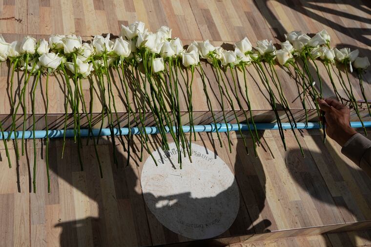 A police officer lays flowers during a ceremony for those killed in the attack on the Young Children's Development Center in the rural town of Uthai Sawan, Thailand, on Friday.