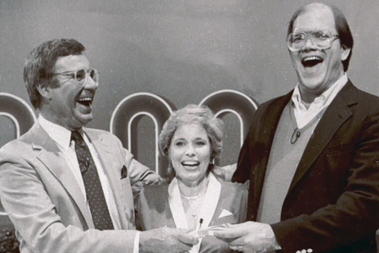 File-This Jan. 16, 1986. file photo shows host Jim Lange, left, congratulating Connie and Steve Rutenbar of Mission Viejo, Calif., after they won $1 million on the TV show " The $1,000,000 Chance of a Lifetime". Lange, the first host of the popular game show "The Dating Game," has died at his home in Mill Valley, Calif. He was 81. He died Tuesday morning after suffering a heart attack, his wife Nancy told The Associated Press Wednesday, Feb. 26, 2014. (AP Photo/File)