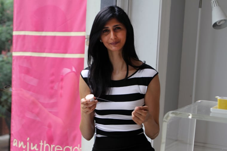 Anju Treohan, owner of Anju Threads, sits by the window in her salon in Philadelphia, on Tuesday, July 2, 2013. ( Stephanie Aaronson / Staff Photographer )
