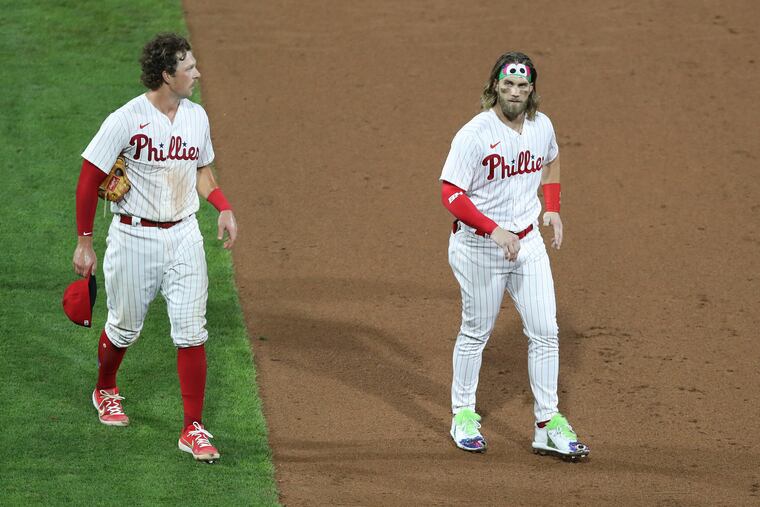 Bryce Harper, right, walks off the field Friday night wearing custom-designed Phanatic-themed cleats.